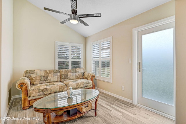 living room featuring ceiling fan, light hardwood / wood-style floors, and vaulted ceiling