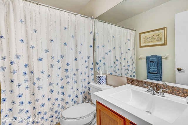 bathroom featuring vanity, decorative backsplash, and toilet