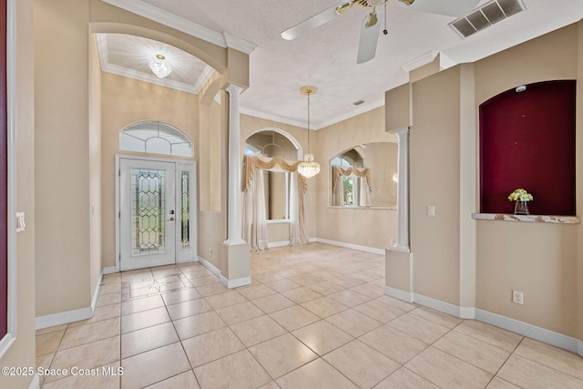 entryway featuring light tile patterned floors, ornamental molding, a textured ceiling, and ornate columns