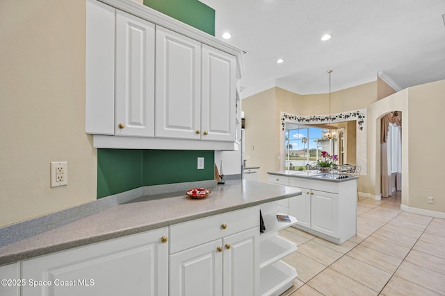 kitchen featuring ornamental molding, decorative light fixtures, light tile patterned floors, and white cabinets