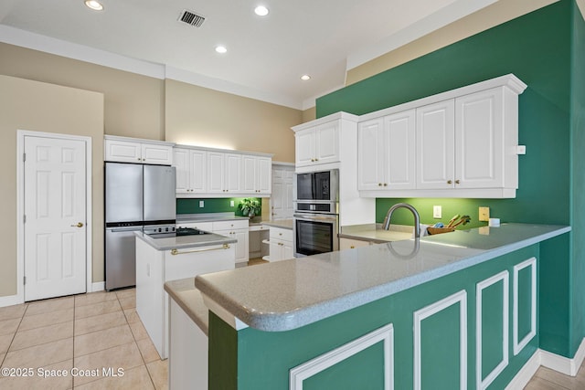 kitchen featuring white cabinetry, a center island, light tile patterned floors, kitchen peninsula, and stainless steel appliances