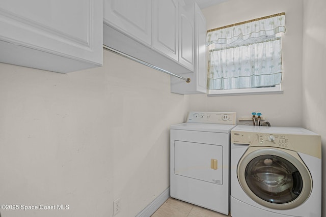 laundry area with separate washer and dryer, light tile patterned floors, and cabinets