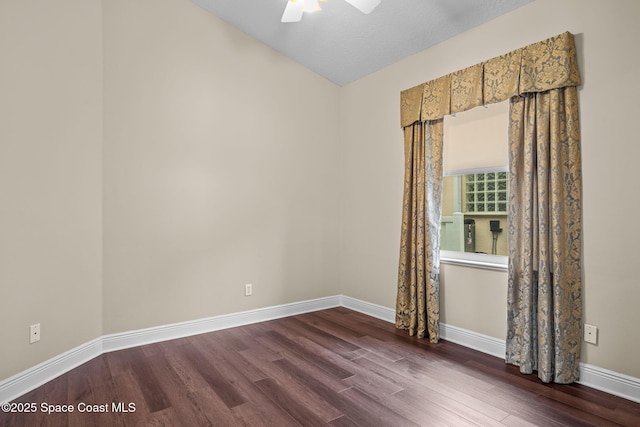 spare room with dark wood-type flooring and ceiling fan