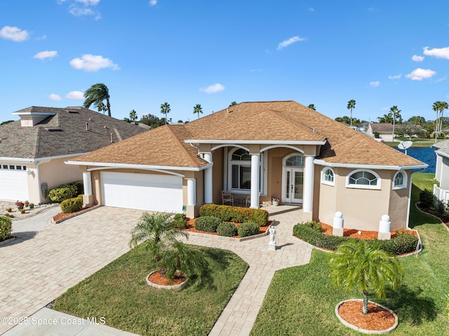 view of front of house with a garage, french doors, and a front lawn