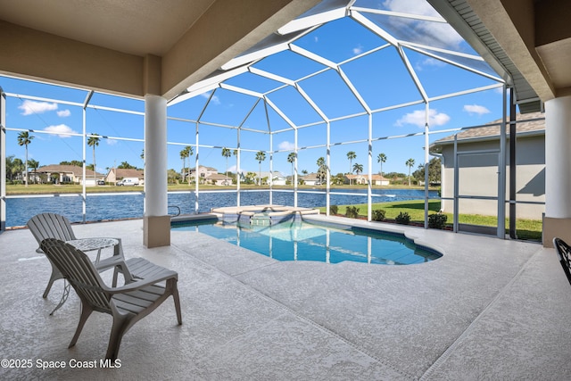 view of pool featuring an in ground hot tub, a water view, glass enclosure, and a patio area