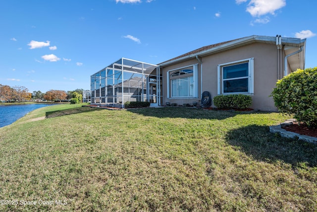 exterior space with a water view, glass enclosure, and a front yard