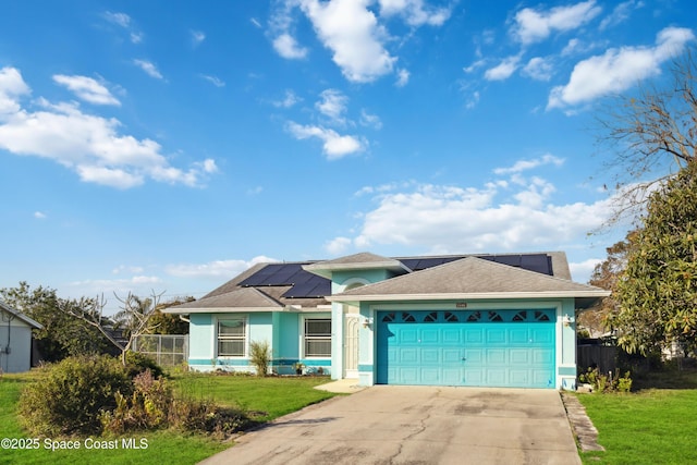 view of front of home with a garage, a front yard, and solar panels