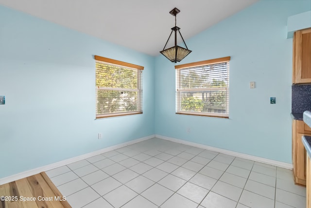 unfurnished dining area featuring plenty of natural light and vaulted ceiling