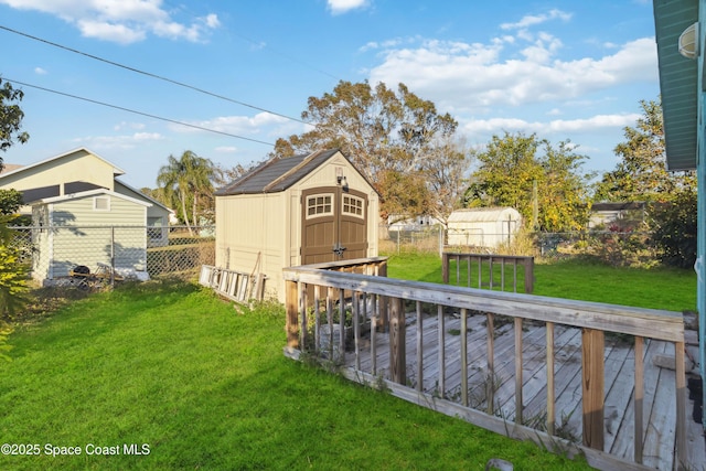 view of yard with a wooden deck and a storage shed