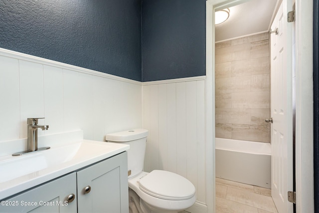 full bathroom featuring toilet, vanity, tile patterned flooring, wood walls, and tiled shower / bath combo