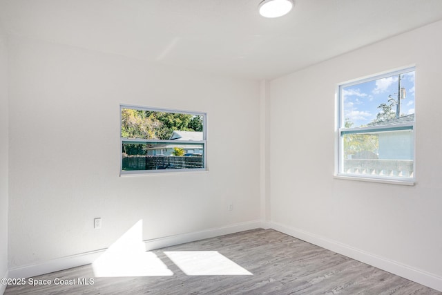 empty room with a healthy amount of sunlight and light hardwood / wood-style floors