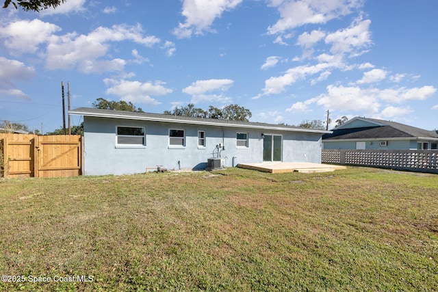 rear view of house with central AC, a lawn, and a patio