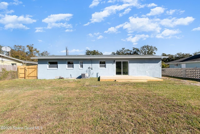 back of house with central AC and a yard