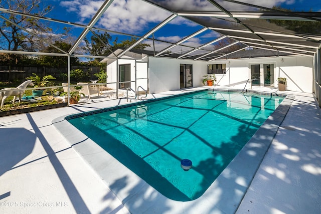 view of swimming pool featuring a patio and glass enclosure