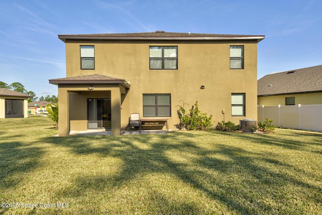 back of property with central AC, a lawn, and a patio area