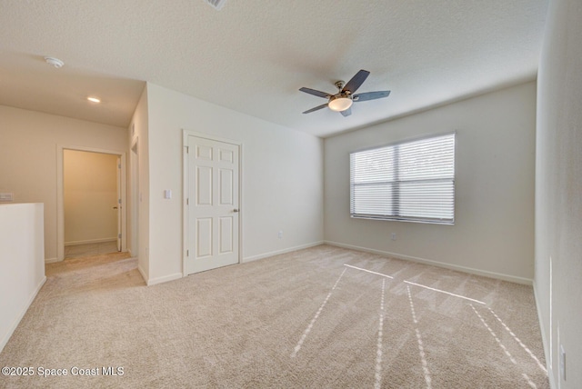 interior space featuring light carpet, ceiling fan, and a textured ceiling