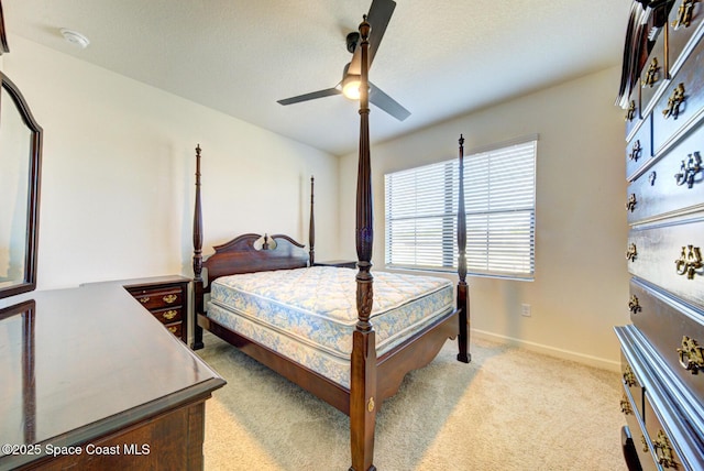 carpeted bedroom featuring a textured ceiling and ceiling fan