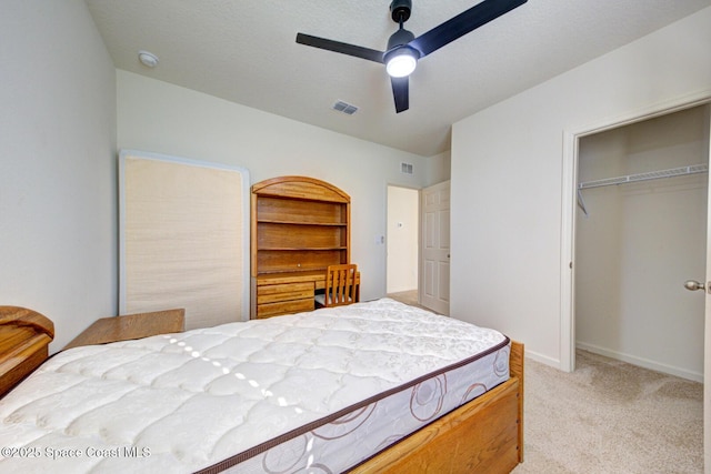 bedroom with light carpet, ceiling fan, and a closet