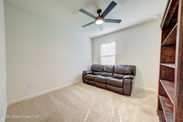 living room featuring light carpet, a textured ceiling, and ceiling fan