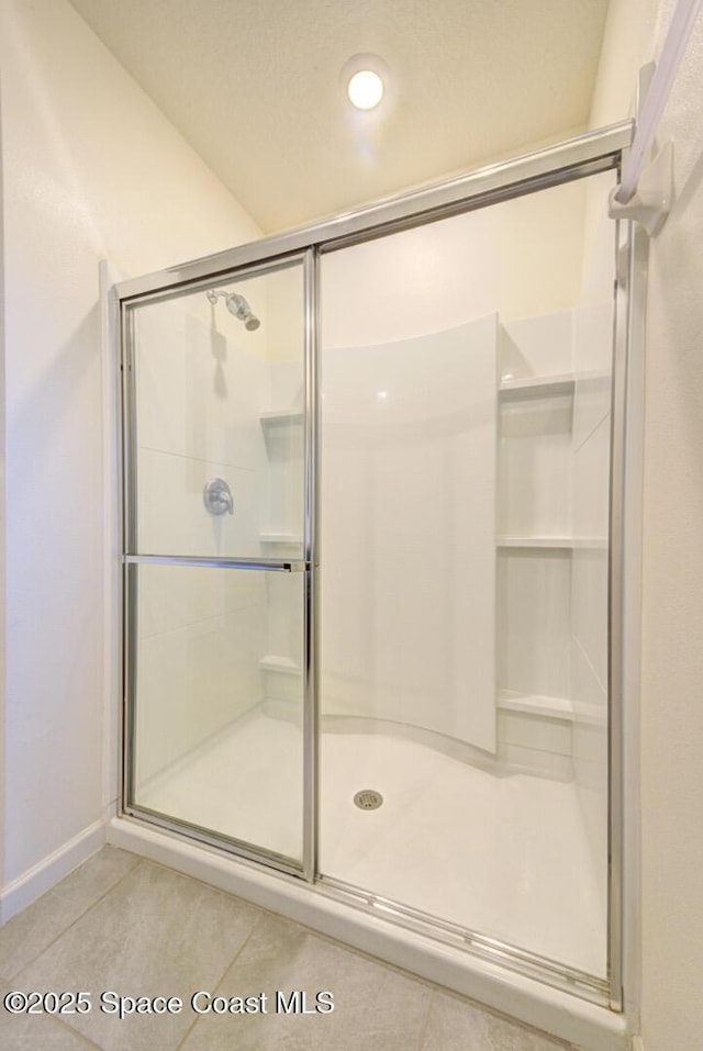 bathroom with tile patterned floors and a shower with shower door