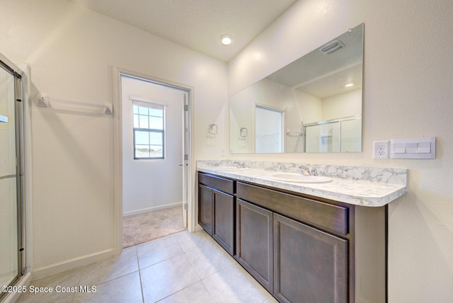 bathroom featuring vanity, tile patterned flooring, and a shower with door