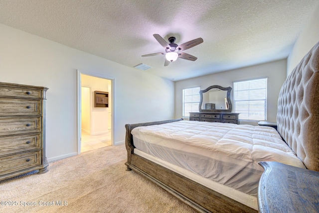 carpeted bedroom featuring ceiling fan, ensuite bath, and a textured ceiling