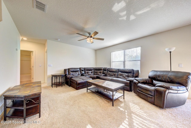 living room with light carpet, a textured ceiling, and ceiling fan