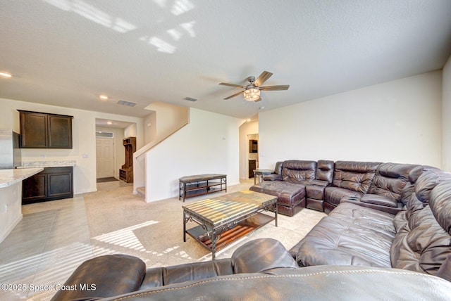 living room with ceiling fan, a textured ceiling, and light tile patterned floors