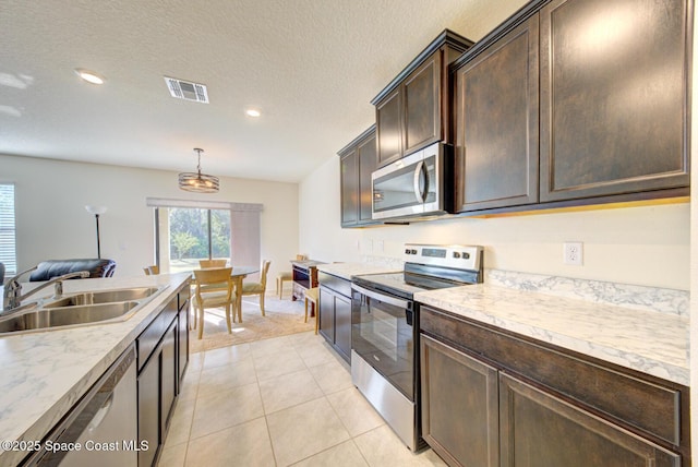 kitchen with appliances with stainless steel finishes, pendant lighting, sink, dark brown cabinets, and a textured ceiling