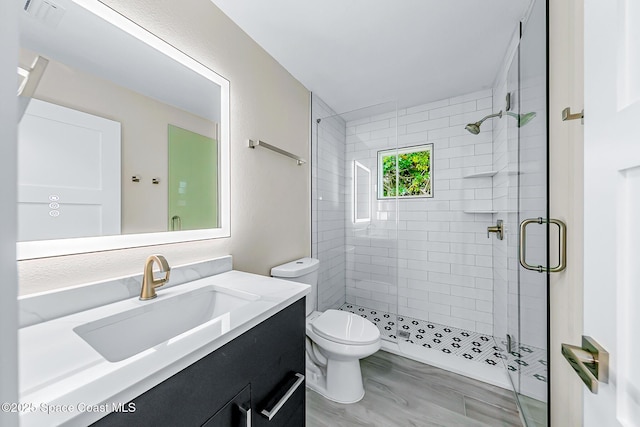 bathroom featuring vanity, toilet, and an enclosed shower