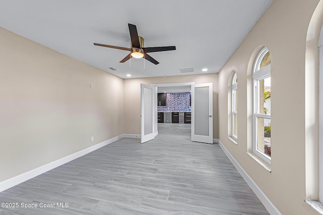 unfurnished room with ceiling fan and light wood-type flooring