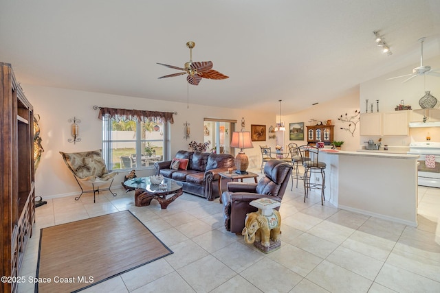 tiled living room with ceiling fan and vaulted ceiling