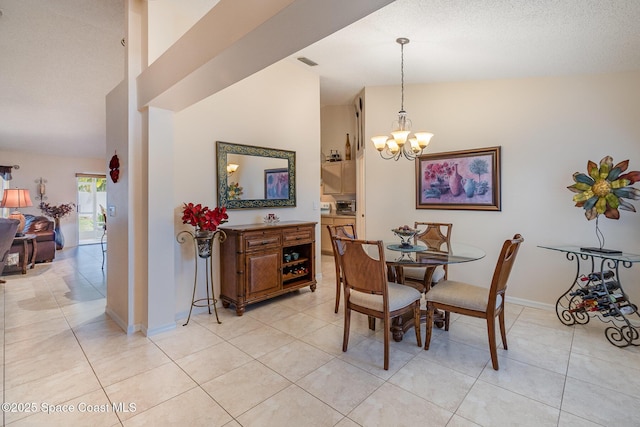 dining area with a textured ceiling, light tile patterned floors, an inviting chandelier, and vaulted ceiling