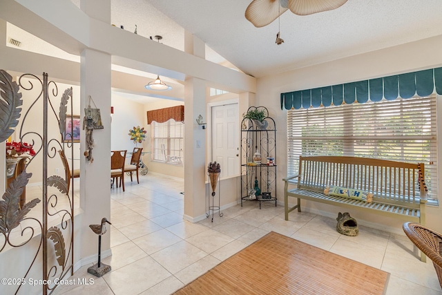 interior space featuring ceiling fan, a textured ceiling, and vaulted ceiling