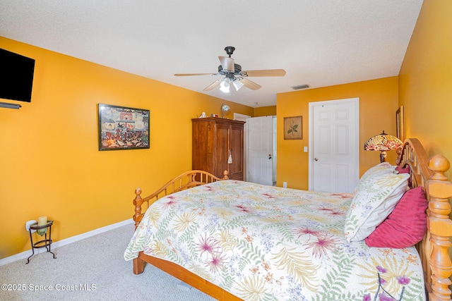 carpeted bedroom featuring ceiling fan and a textured ceiling