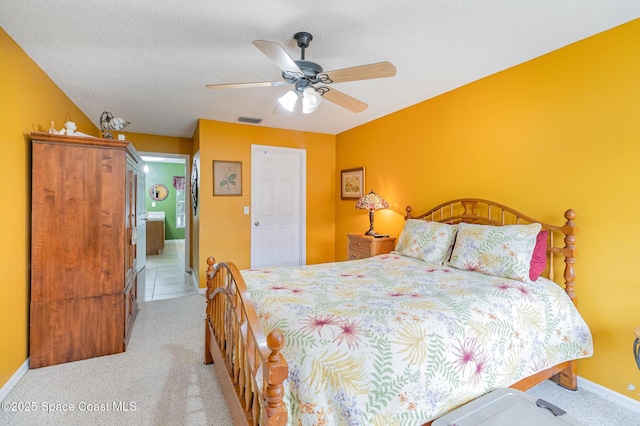 bedroom featuring ceiling fan, a textured ceiling, and light carpet