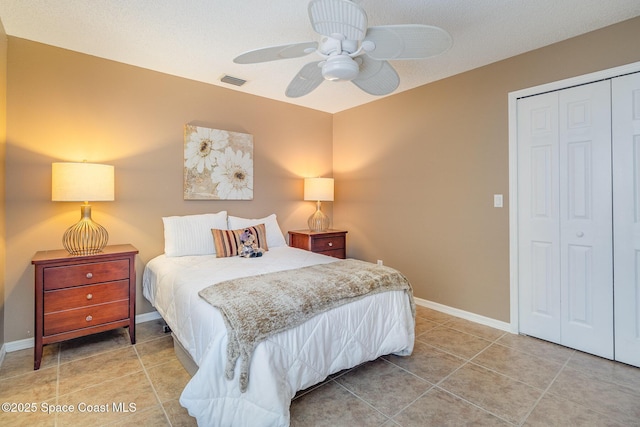 bedroom featuring ceiling fan, a closet, and tile patterned flooring