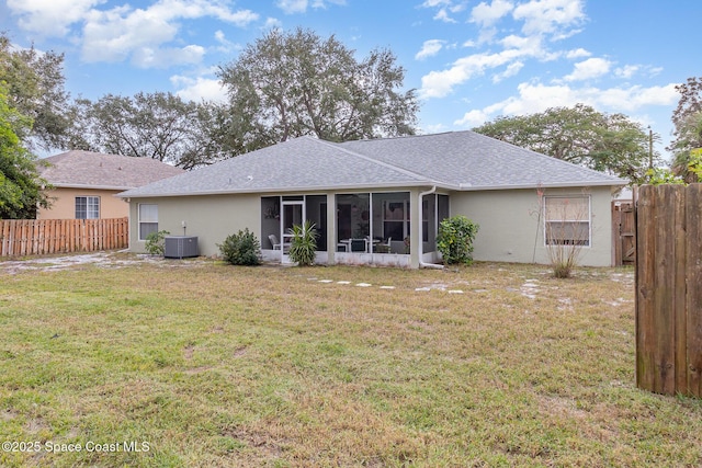 back of house with a sunroom, a yard, and central air condition unit