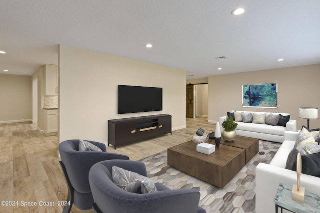 living room featuring a textured ceiling, recessed lighting, visible vents, and light wood-style floors