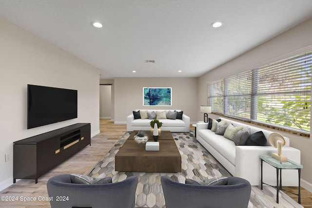 living area featuring baseboards, light wood-type flooring, visible vents, and recessed lighting