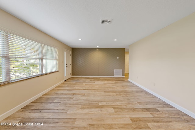 spare room featuring recessed lighting, visible vents, light wood-style flooring, and baseboards