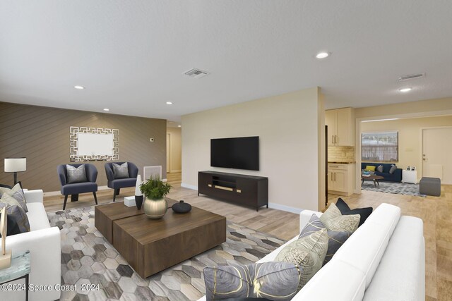 living room featuring light wood-style floors, baseboards, visible vents, and recessed lighting