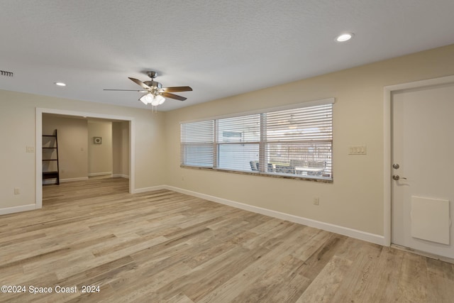 spare room with light wood finished floors, recessed lighting, and baseboards