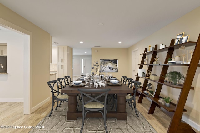 dining space featuring recessed lighting, baseboards, and light wood finished floors