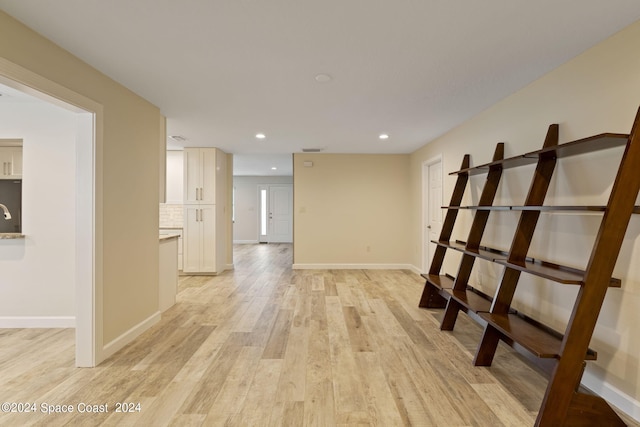 spare room featuring recessed lighting, baseboards, and light wood finished floors