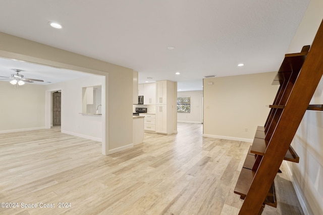 spare room featuring recessed lighting, baseboards, and light wood finished floors