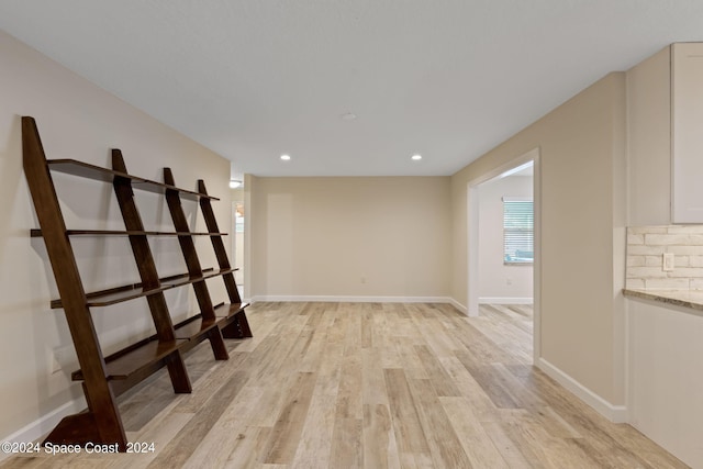 spare room with light wood-type flooring, baseboards, and recessed lighting