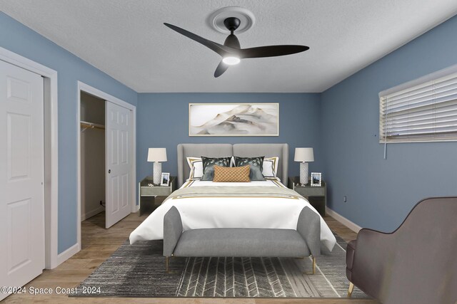 bedroom with baseboards, a ceiling fan, light wood-style flooring, a textured ceiling, and a closet