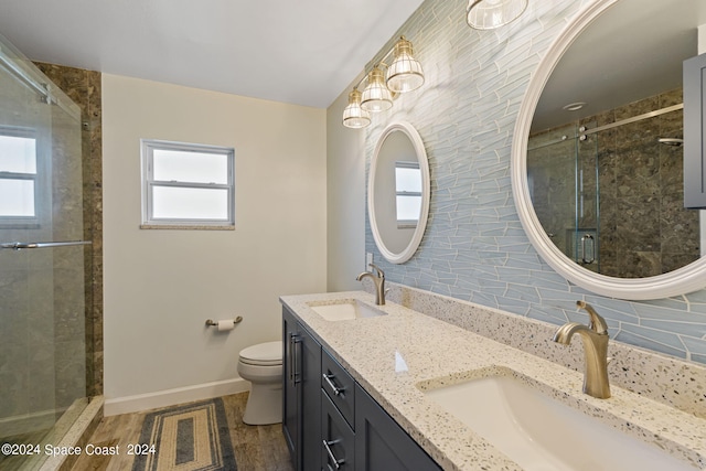 bathroom featuring a stall shower, a sink, toilet, and baseboards