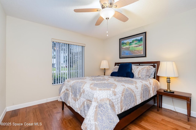 bedroom featuring a ceiling fan, baseboards, and wood finished floors